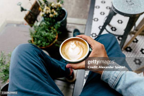 man drinking coffee outdoors, personal perspective view - kaffe trinken stock-fotos und bilder