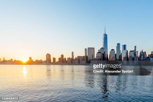 manhattan financial district skyline seen from jersey city at sunrise, usa - sunrise new york stock-fotos und bilder