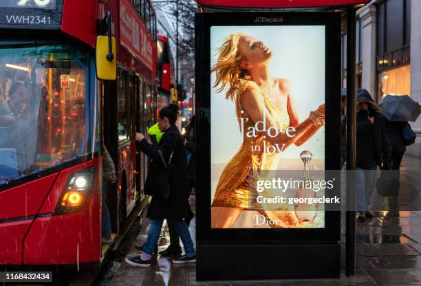 boarding a london bus and bus stop advertising - bus poster imagens e fotografias de stock