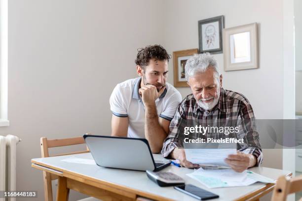 doing home accounts - old man son stock pictures, royalty-free photos & images