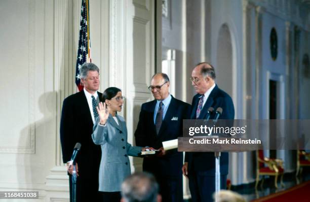 Ruth Bader Ginsburg holds her right hand up as Chief Justice William H Rehnquist administers the oath of office as she is sworn in as Associate...