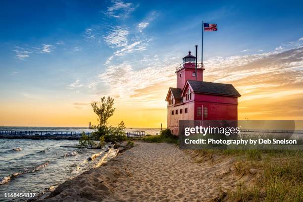 holland harbor light "big red" at sunset lake michigan - holland michigan lighthouse stock pictures, royalty-free photos & images