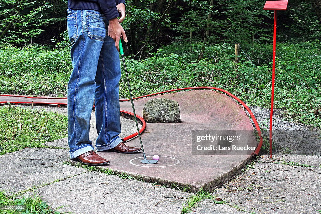 Man playing mini golf