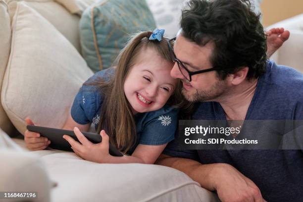 young girl with down syndrome giggles with dad - adoption child family stock pictures, royalty-free photos & images