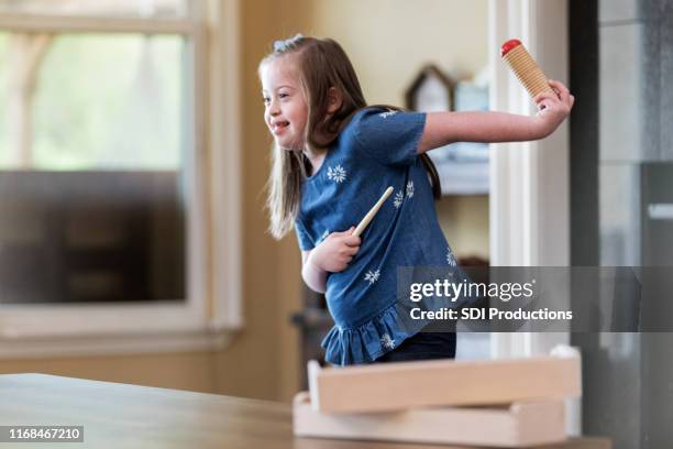 young girl with down syndrome plays instrument and dances - mental disability stock pictures, royalty-free photos & images