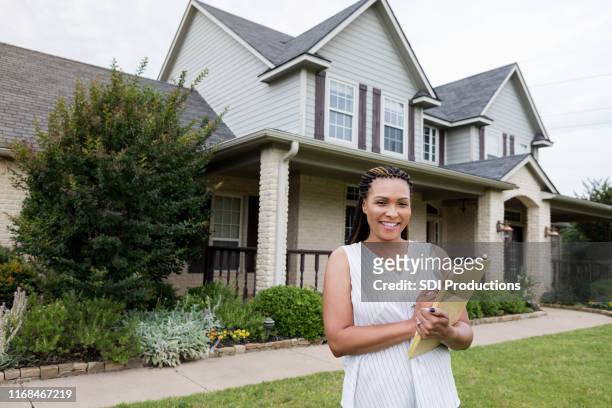 attractive female real estate agent checks home for sale - real estate agent stock pictures, royalty-free photos & images