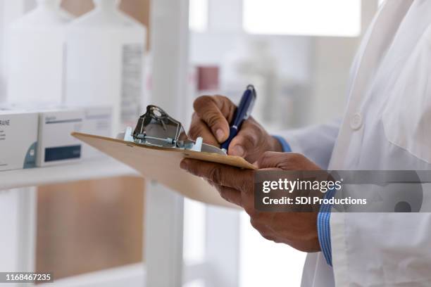 pharmacist writes on clipboard - generic drug stock pictures, royalty-free photos & images