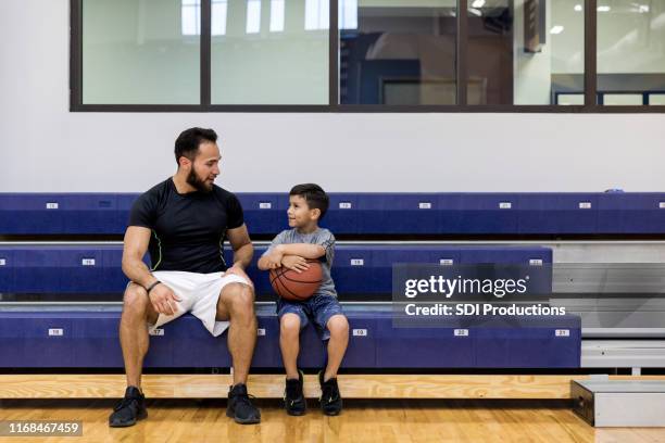 mid adult uncle and young nephew take break at gym - uncle stock pictures, royalty-free photos & images