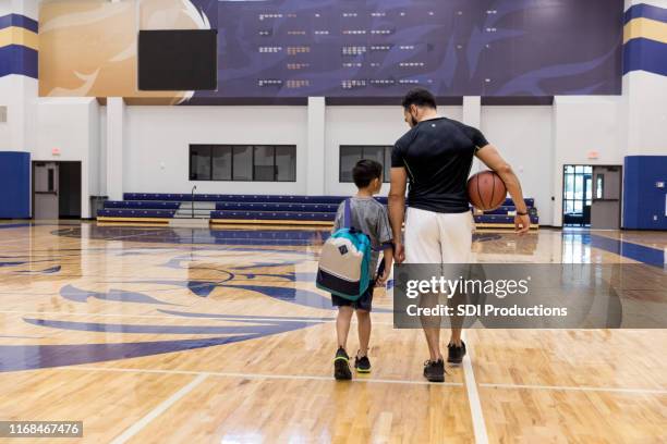 father and son walk away from basketball court after game - uncle stock pictures, royalty-free photos & images
