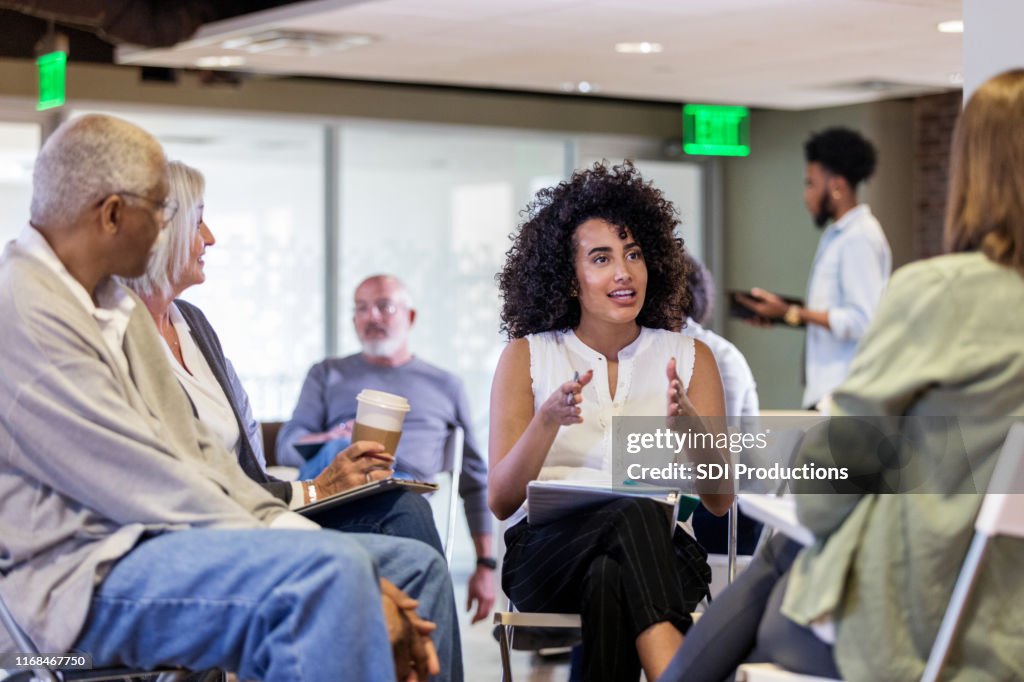 Mid adult woman speaks with emphasis at homeowners meeting