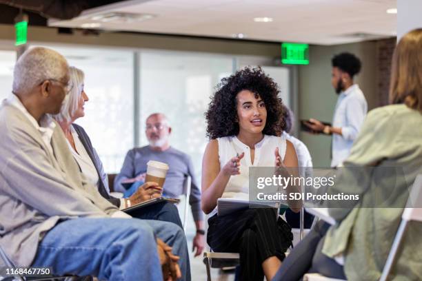 mid adult woman speaks with emphasis at homeowners meeting - focus group discussion stock pictures, royalty-free photos & images