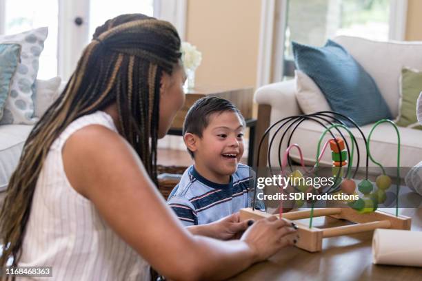 happy young boy playing with bead maze - child genetics stock pictures, royalty-free photos & images
