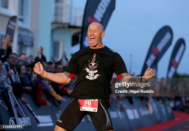 Former Welsh rugby International captain Gareth Thomas reacts after finishing Ironman Wales on September 15, 2019 in Tenby, Wales.