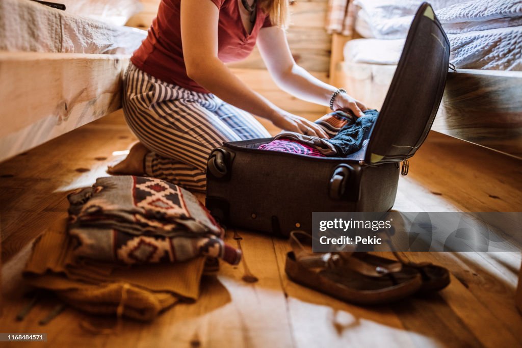 Mujer irreconocible que empaca el equipaje en la cabina de registro