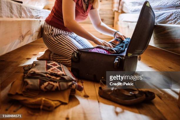 unrecognizable woman packing luggage in log cabin - suitcase stock pictures, royalty-free photos & images