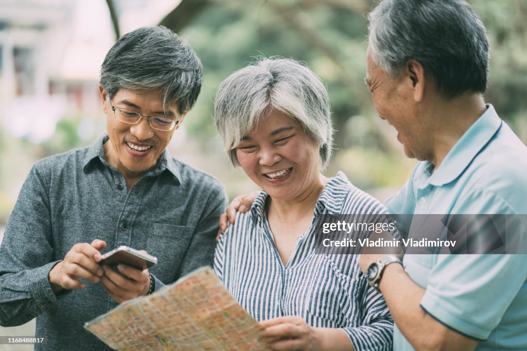 Asian family using a map on street