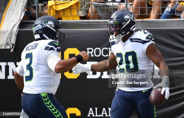 Rashaad Penny of the Seattle Seahawks celebrates his touchdown with Russell Wilson during the third quarter against the Pittsburgh Steelers at Heinz...