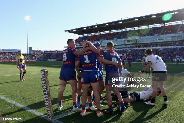 Kalyn Ponga of the Newcastle Knights celebrates his try with team mates during the round 22 NRL match between the Newcastle Knights and the North...