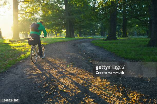 young man cycling in richmond park, london - richmond park london stock pictures, royalty-free photos & images