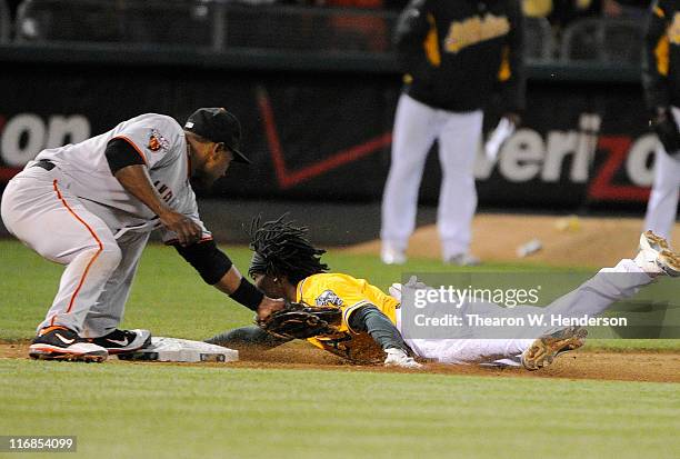 Jemile Weeks of the Oakland Athletics, attempting to stretch a double into a triple, is tagged out at third base by Miguel Tejada of the San...