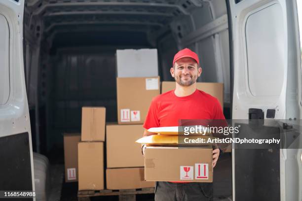portrait of delivery man in front of delivery van. - delivery man stock pictures, royalty-free photos & images