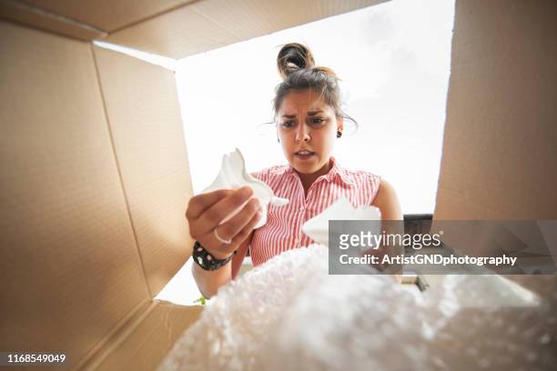 uma mulher nova abre uma caixa com uma expedição quebrada - open grave - fotografias e filmes do acervo