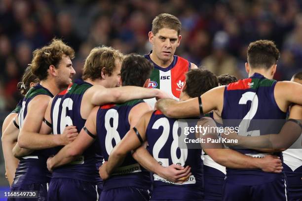 Aaron Sandilands of the Dockers looks on as the team huddles during the round 22 AFL match between the Fremantle Dockers and the Essendon Bombers at...