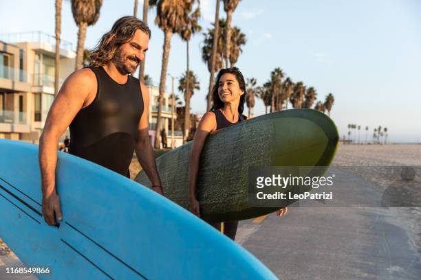 cool paar in venetië gaan surfen in de stille oceaan - venice with couple stockfoto's en -beelden