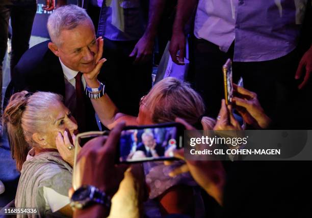 Retired Israeli General Benny Gantz , one of the leaders of the Blue and White political alliance, is greeted by supporters at a campaign event in...