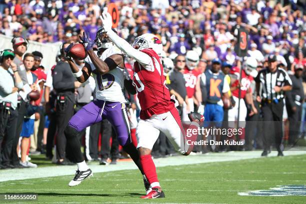 Marquise Brown of the Baltimore Ravens makes a catch over Tramaine Brock of the Arizona Cardinals during the second half at M&T Bank Stadium on...