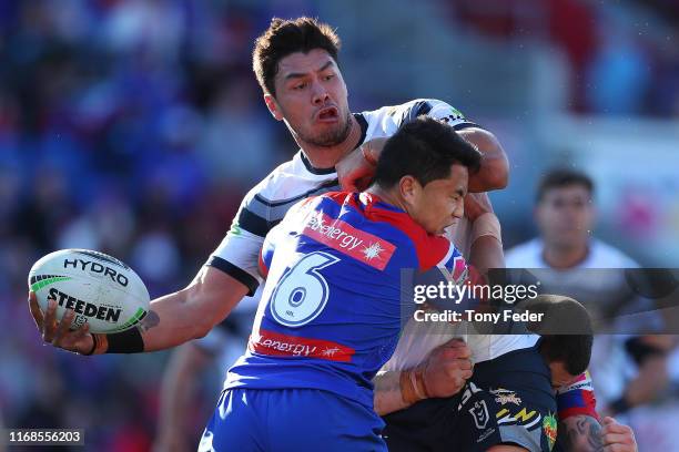 Jordan McLean of the North Queensland Cowboys is tackled during the round 22 NRL match between the Newcastle Knights and the North Queensland Cowboys...