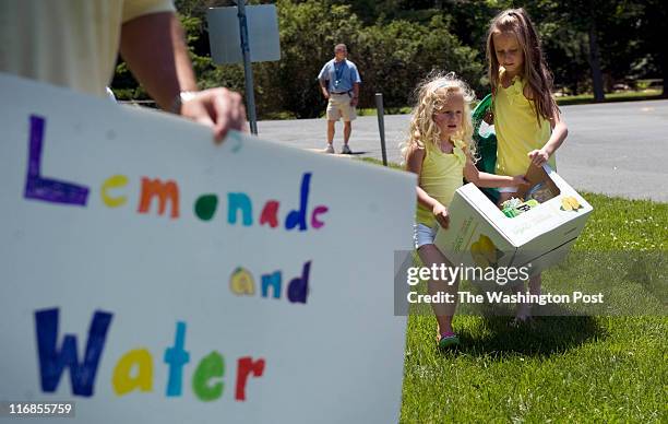 Sofia Fernandez right, helps her sister Alina Fernandez move their lemonade stand 50 feet from the corner of River and Harrington Dr. On Friday, June...