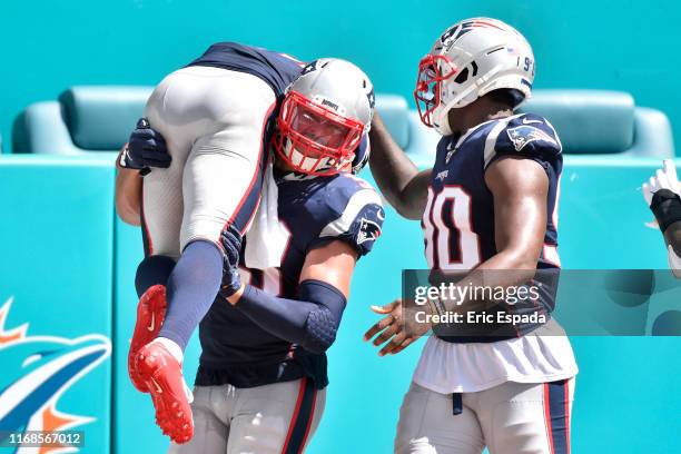 Kyle Van Noy of the New England Patriots carries Stephon Gilmore after he returned an interception for a touchdown during the fourth quarter against...