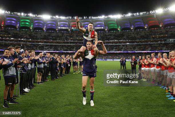 Aaron Sandilands of the Dockers carries Hayden Ballantyne thru a guard of honour after playing their final games for the club during the round 22 AFL...