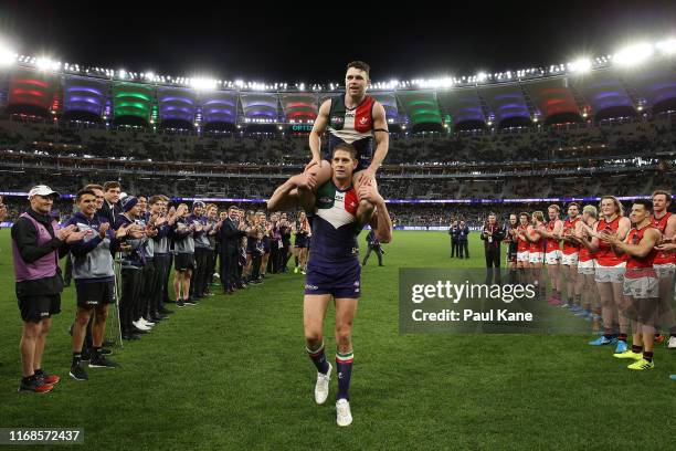 Aaron Sandilands of the Dockers carries Hayden Ballantyne thru a guard of honour after playing their final games for the club during the round 22 AFL...