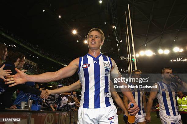 Liam Anthony of the Kangaroos celebrates with fans after the round 13 AFL match between the Essendon Bombers and the North Melbourne Kangaroos at...