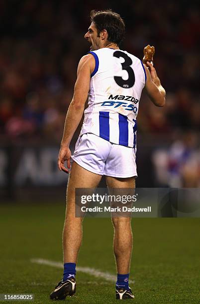 Annoyed Brady Rawlings of the Kangaroos throws a coke bottle to the boundary line after it was thrown in his direction during the round 13 AFL match...