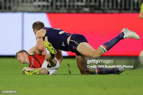 Brayden Ham of the Bombers is tackled by Aaron Sandilands of the Dockers during the round 22 AFL match between the Fremantle Dockers and the Essendon...