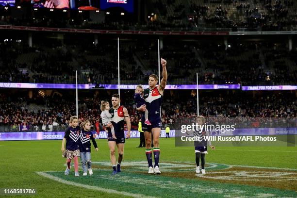 Retiring players Aaron Sandilands and Hayden Ballantyne of the Dockers leave the field with their children after during the round 22 AFL match...