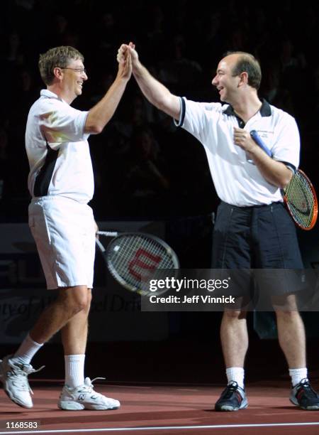 Microsoft founder Bill Gates and Amazon.com founder Jeff Bezos high-five prior to their celebrity pro-am set during the Schick XTreme III Tennis...