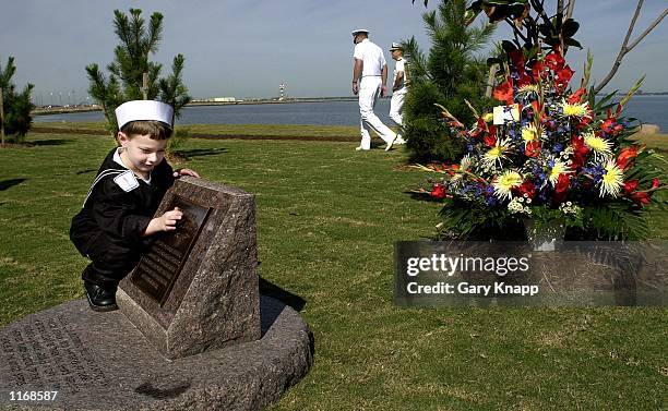 Five-year-old Eathan Costelow touches a part of the USS Cole memorial at Norfolk Naval Base October 12, 2001 in Norfolk, VA. Eathan's father, Richard...