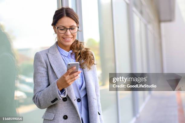 affärskvinna med hjälp av mobilappen - brunette woman eyeglasses beautiful bildbanksfoton och bilder