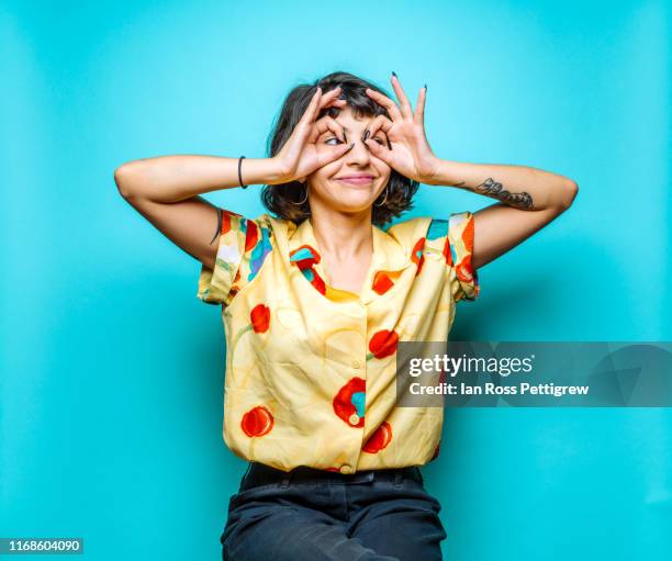 young woman making funny faces - fondo con color fotografías e imágenes de stock