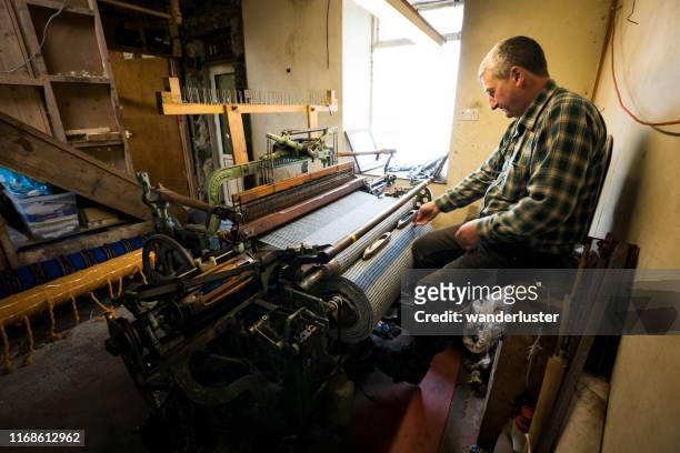 uno dei tessitori di stoffa di tweed impegnati al lavoro sull'isola di lewis - uccello tessitore foto e immagini stock