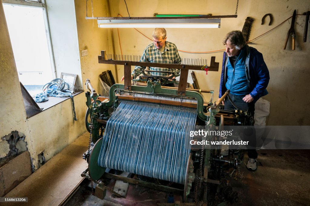 Tourist watches a tweed cloth weaver