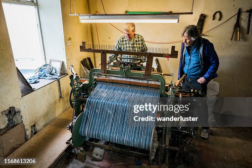Tourist watches a tweed cloth weaver Tourist watches a tweed cloth weaver