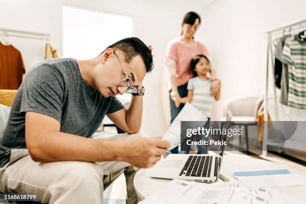 man working at home while wife and daughter playing - worried family stock pictures, royalty-free photos & images