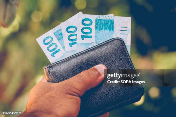 In this photo illustration the hundred reais banknotes seen in a wallet. The Real is the current money in Brazil.