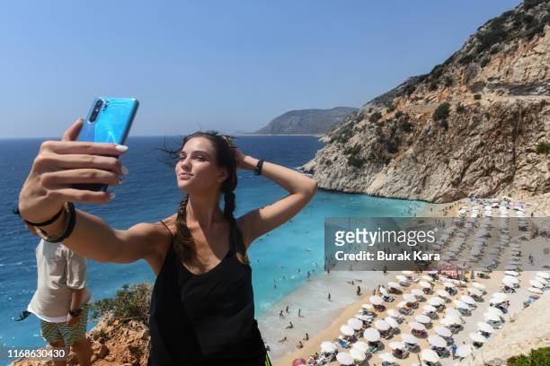 Woman pose for a selfie in Kaputas beach on August 17, 2019 in Kas, Turkey. Turkey’s resort towns saw a 100 percent occupancy rate with the Eid...