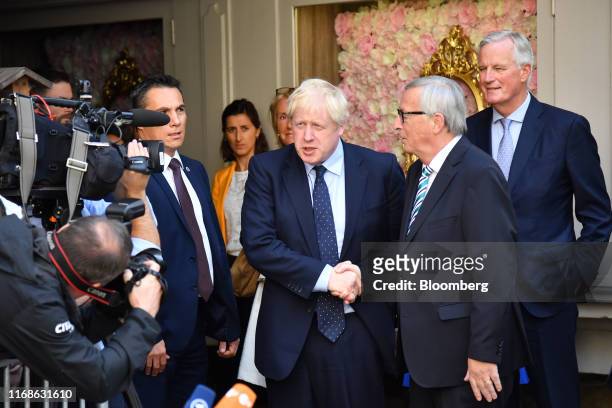 Boris Johnson, U.K. Prime minister, center, speaks to journalists while shaking hands with Jean-Claude Juncker, president of the European Commission,...
